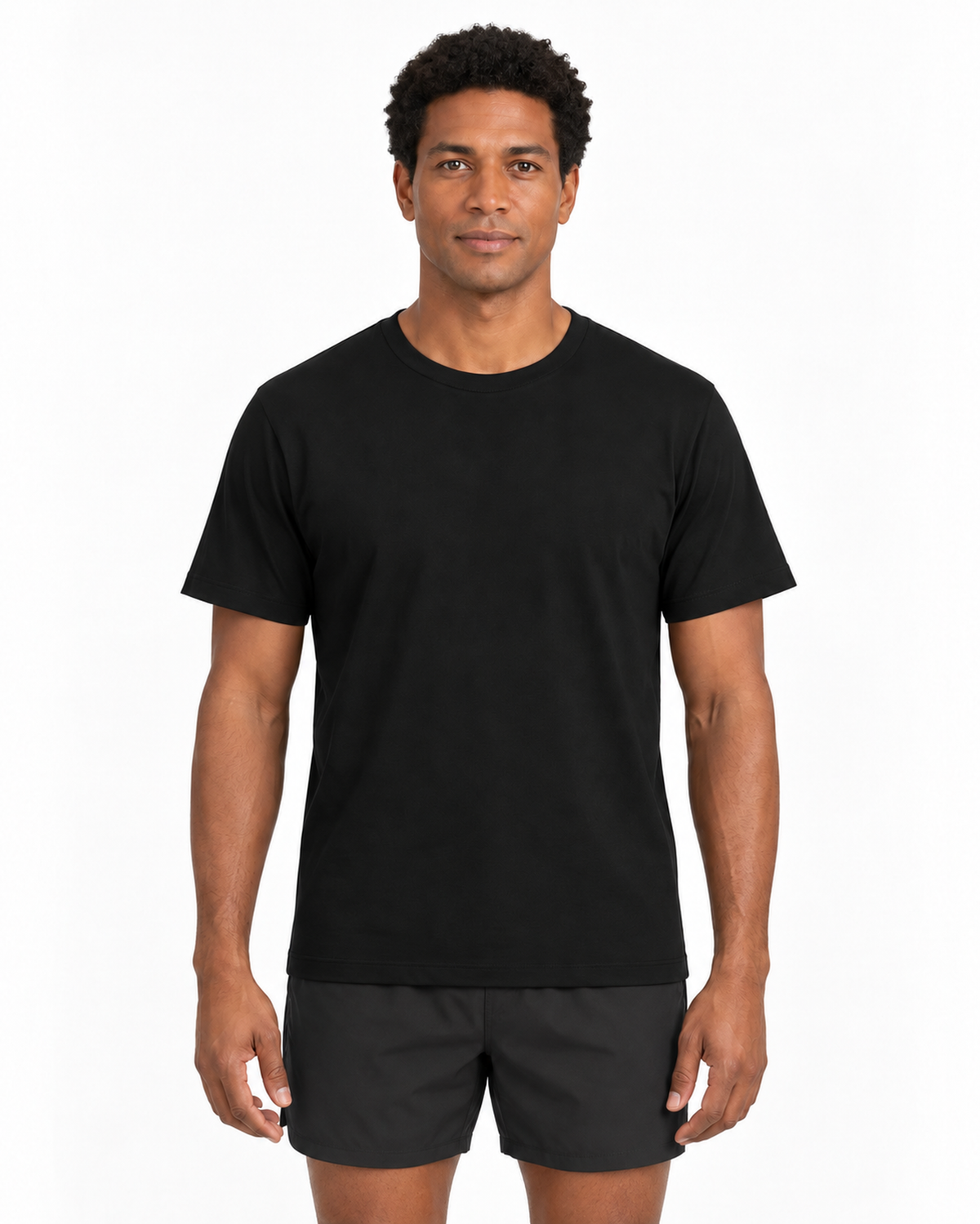 Modelo masculino com Camiseta Algodão Peruano Essencial preta e shorts esportivos em estúdio