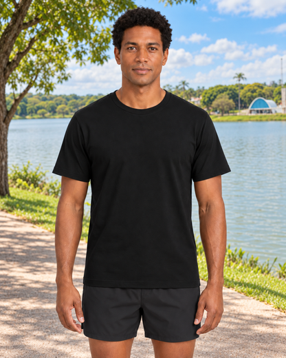 Mesmo modelo masculino com Camiseta Algodão Peruano Essencial preta em cenário ilustrativo inspirado na Pampulha