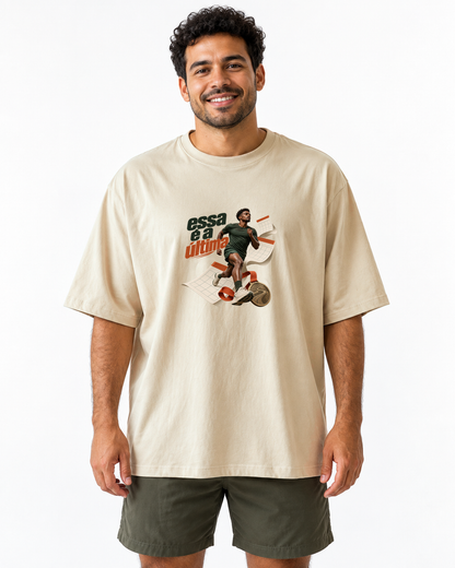 Inscrição Inevitável — camiseta oversized Entrevoltas — modelo masculino — areia — estúdio