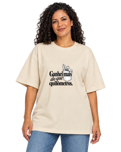 Mulher com camiseta oversized Areia Conquista de Rua em fundo claro.