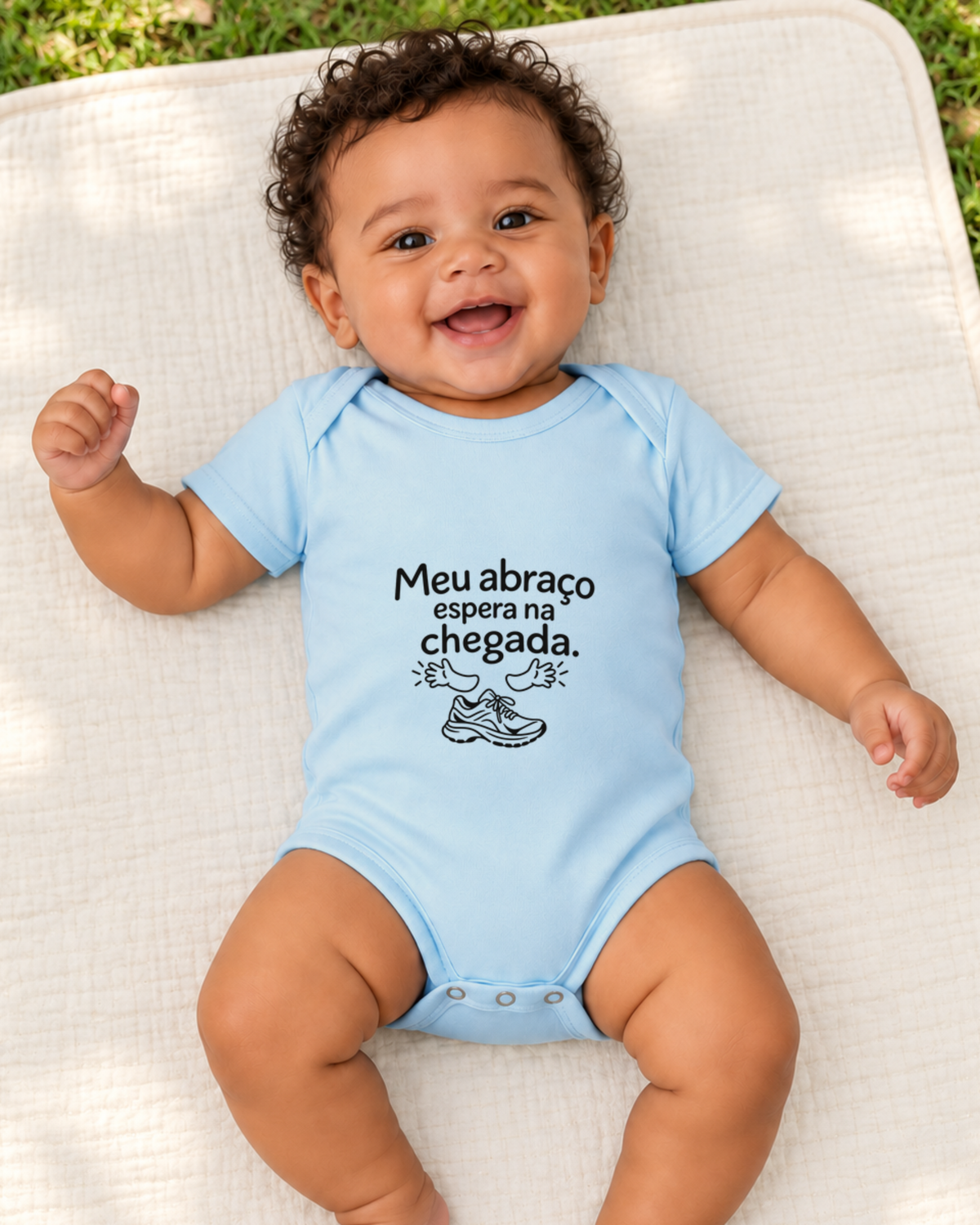 Bebê com body azul bebê Abraço na Chegada em ambiente externo.
