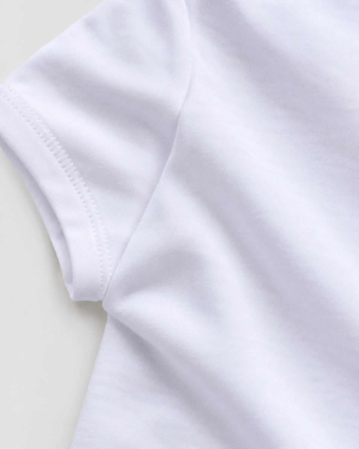 Detalhe da costura da manga e lateral do body branco.