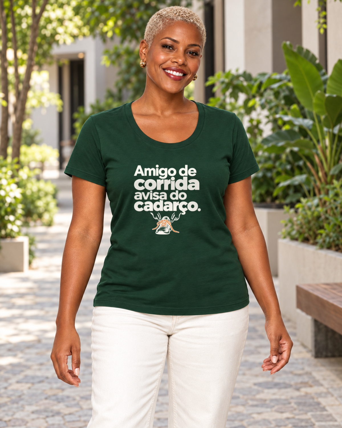 Mulher com camiseta verde Cuidado Pequeno em ambiente externo.