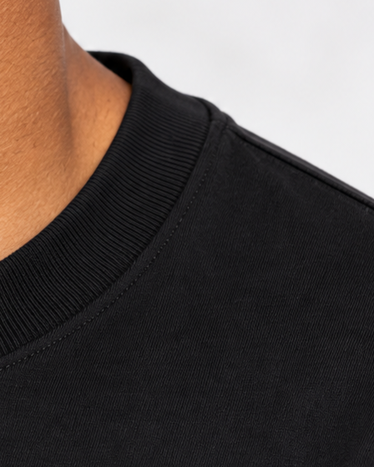 Detalhe da gola canelada e costura do ombro da camiseta oversized preta
