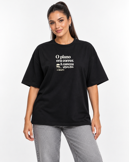 Mulher com camiseta oversized preta Planejamento Generoso em fundo claro.