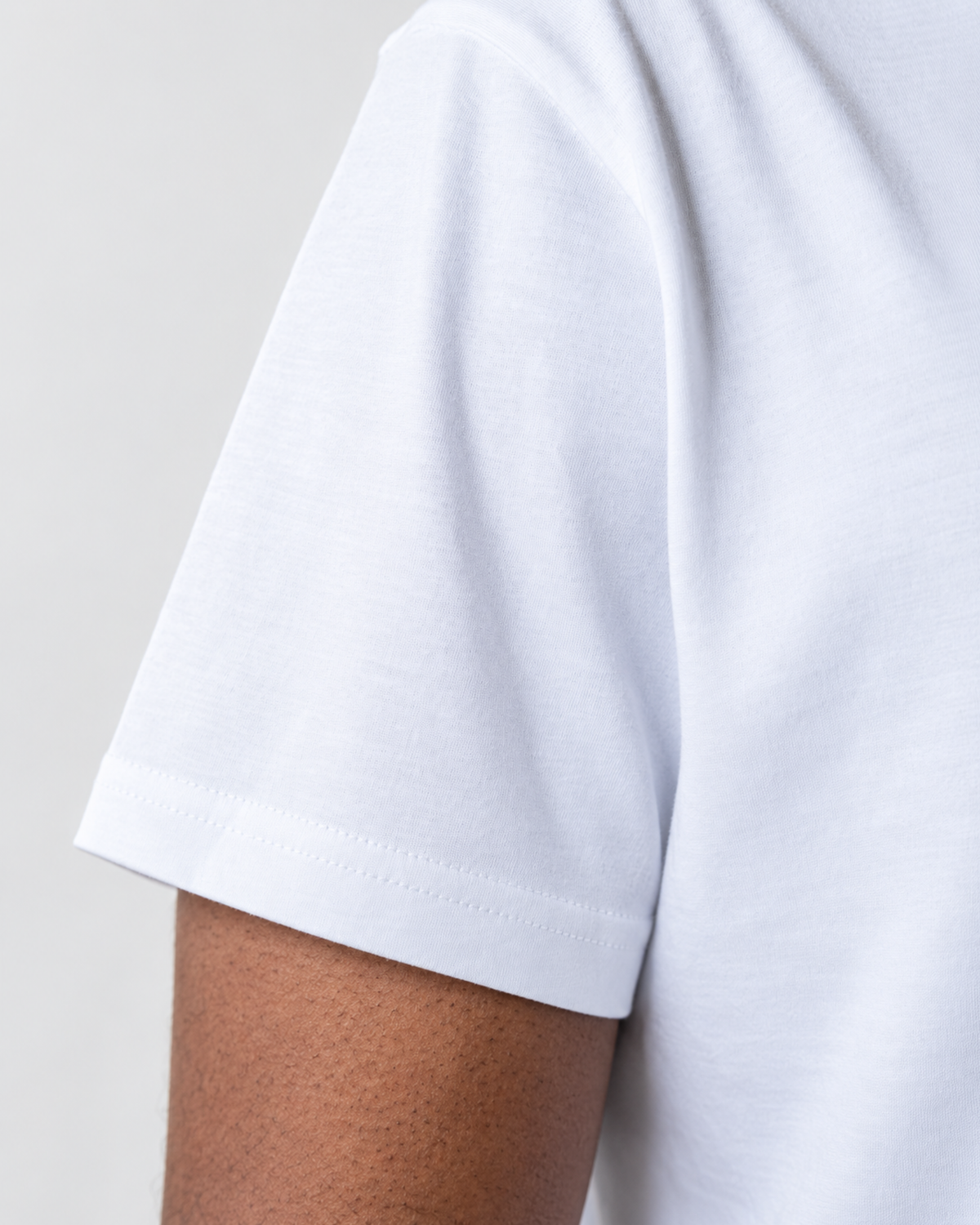 Detalhe da manga da camiseta branca.