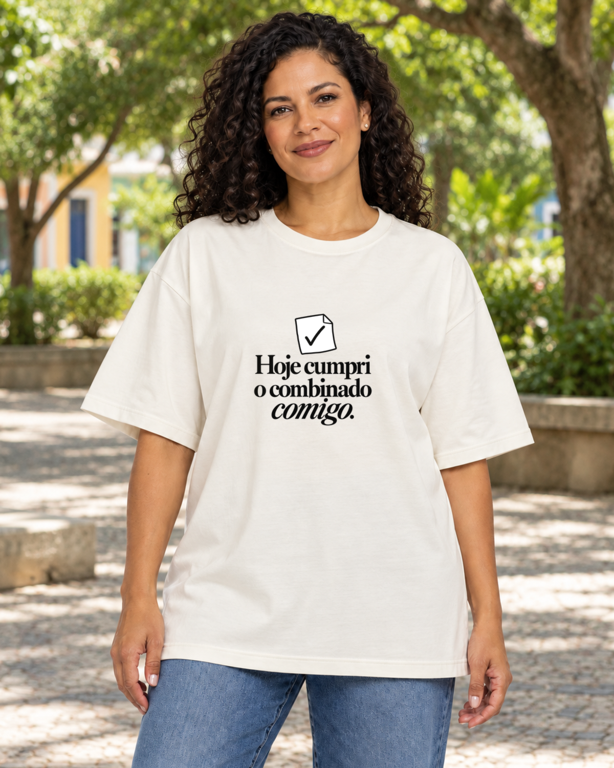 Mulher com camiseta oversized Off White Pequeno Plano Cumprido em ambiente externo.