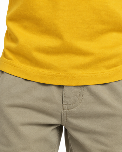 Detalhe da barra da camiseta infantil amarela.