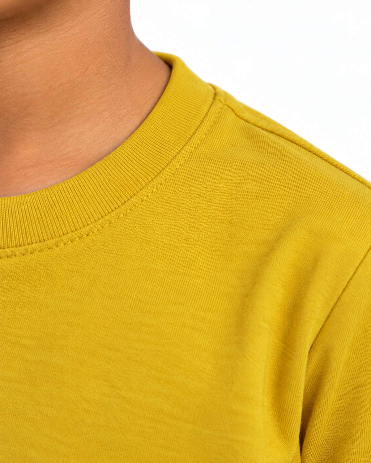 Detalhe lateral da gola e costura do ombro da camiseta infantil amarela.